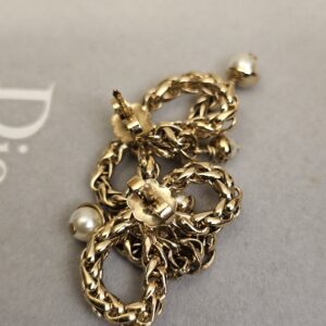 Close up of one Christian Dior braided bow earring with its pearl accents
