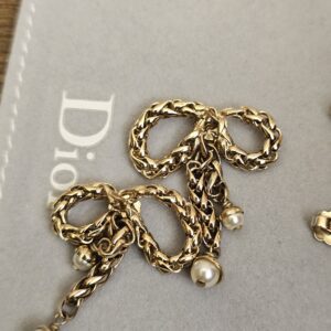 Christian Dior bow earrings showing the faux pearl drops and gold-tone finish