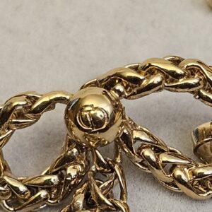 Extreme close up of the braided bow and the gold ball at the centre of the Dior earring