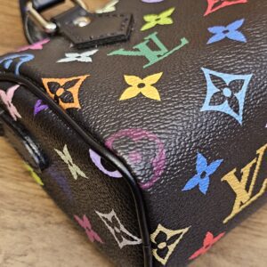Corner of the bag showing the leather piping against the multicolor canvas