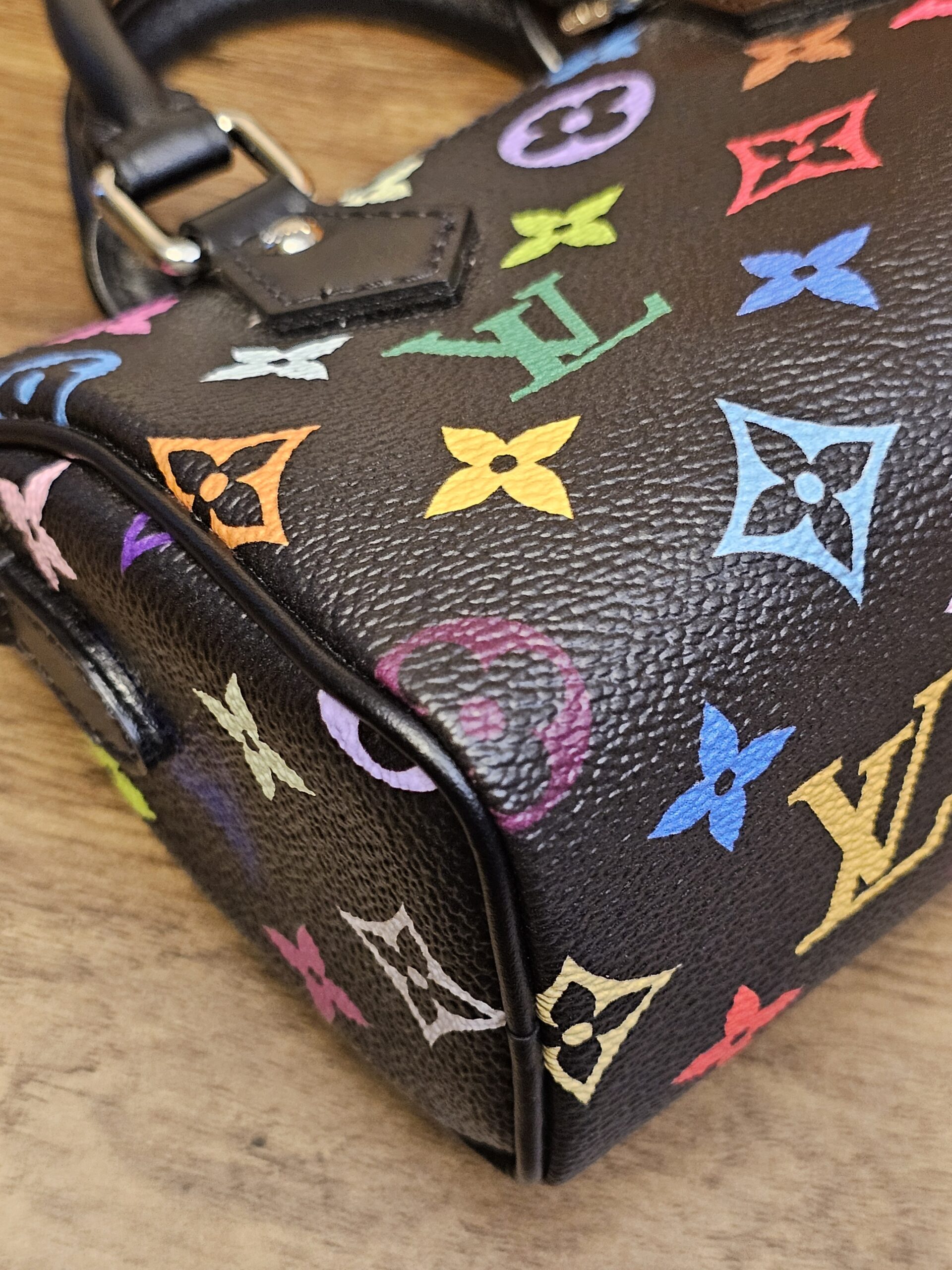 Corner of the bag showing the leather piping against the multicolor canvas