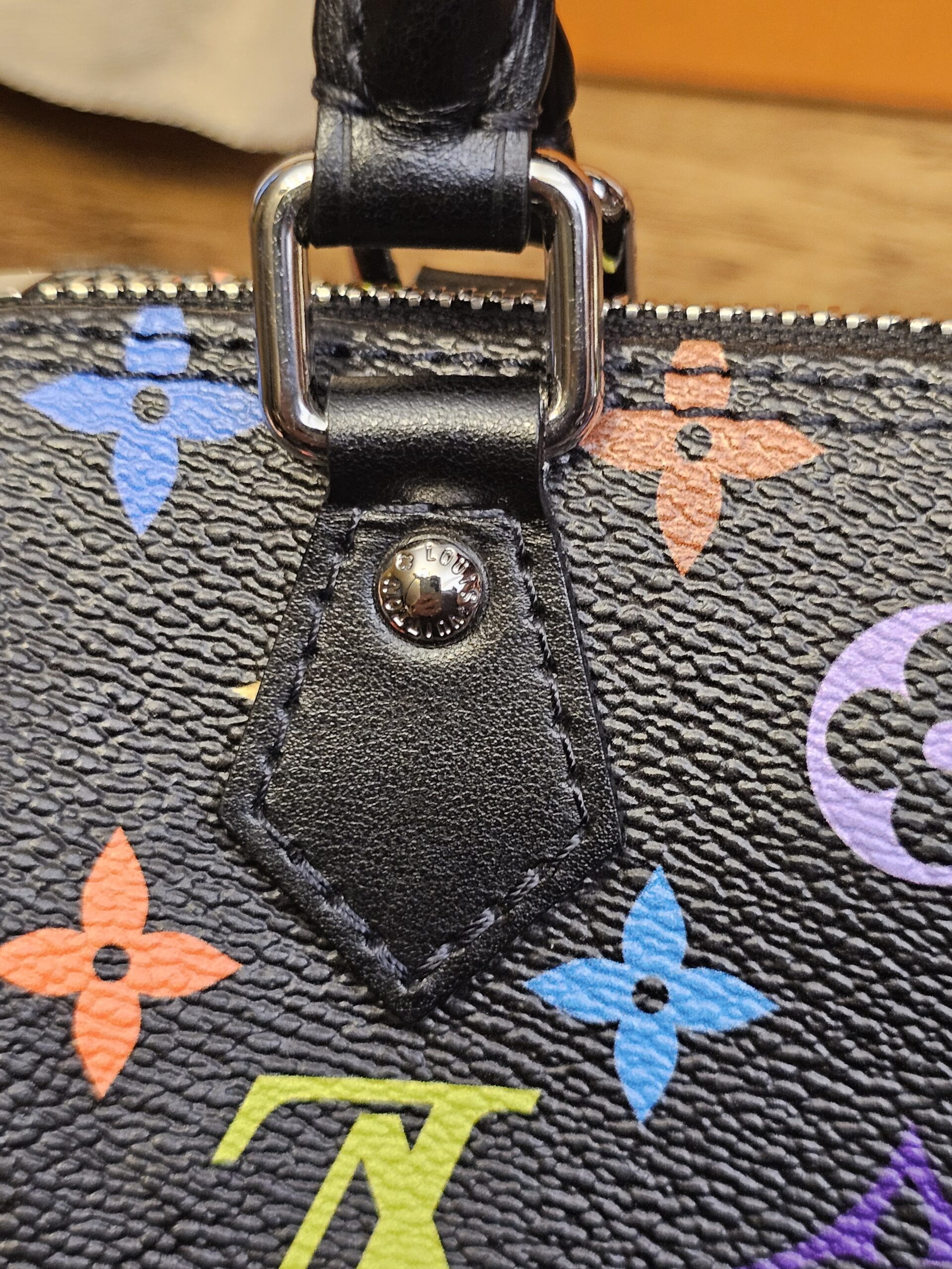 Close up of the black leather tab and rivet at the base of the handle