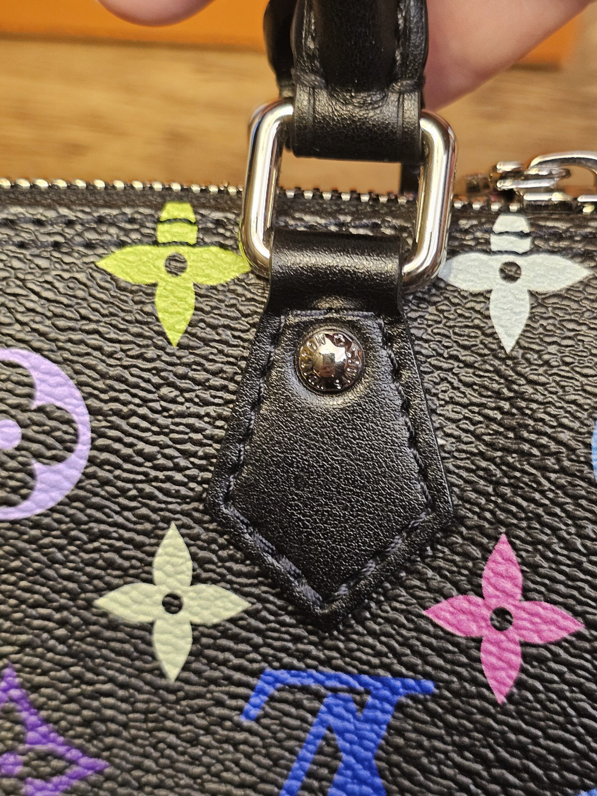 Leather handle tab and rivet on the other side of the bag