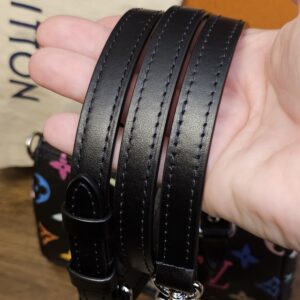 Removable black leather shoulder strap held in hand