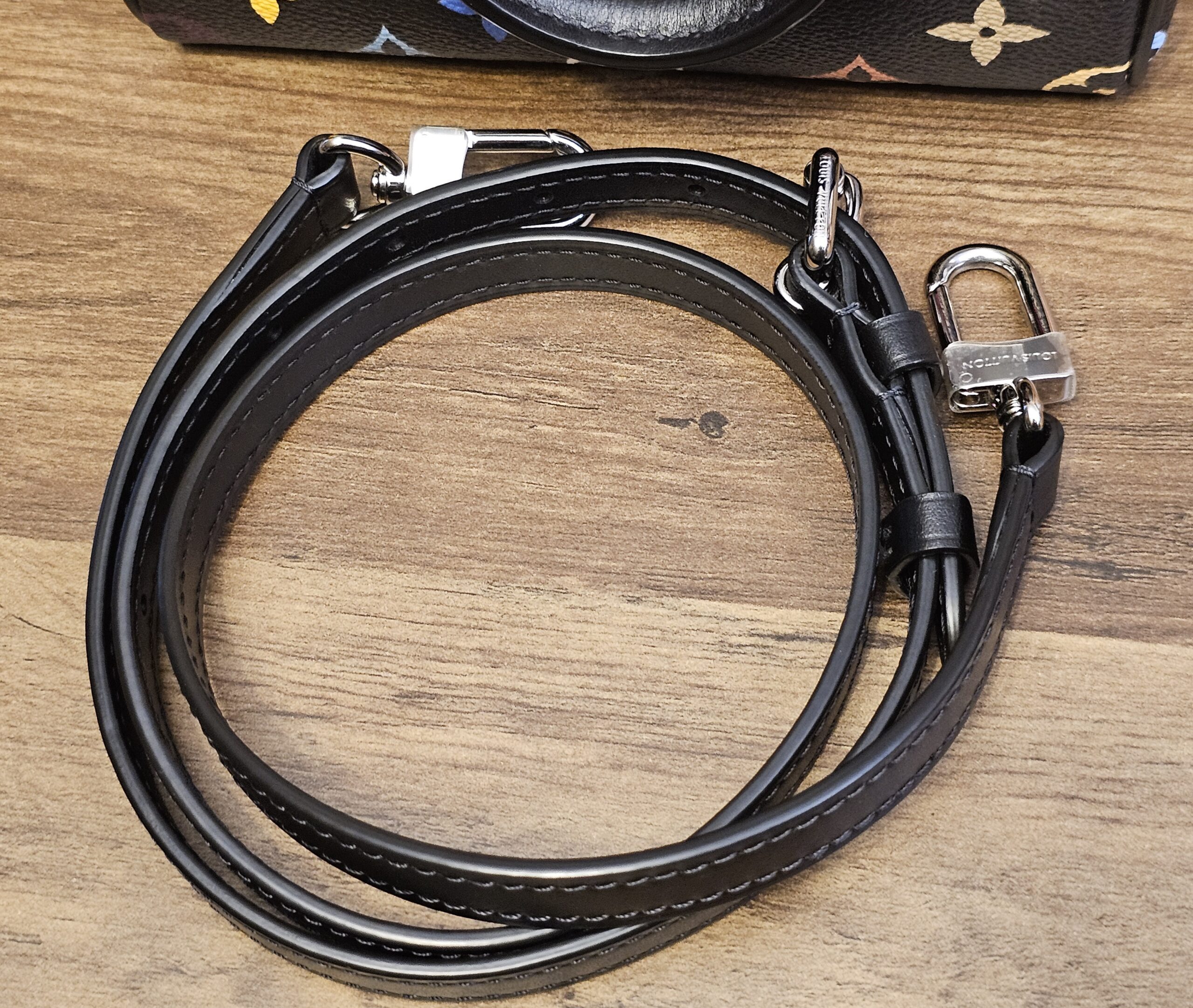 Coiled black leather strap with its silver-tone clasps