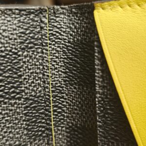 Close up of wear and cracking along the edge of the Damier Graphite canvas
