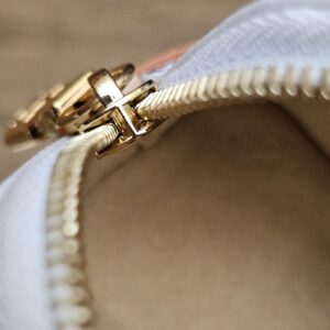 Close up of the zip opening and gold-tone pull