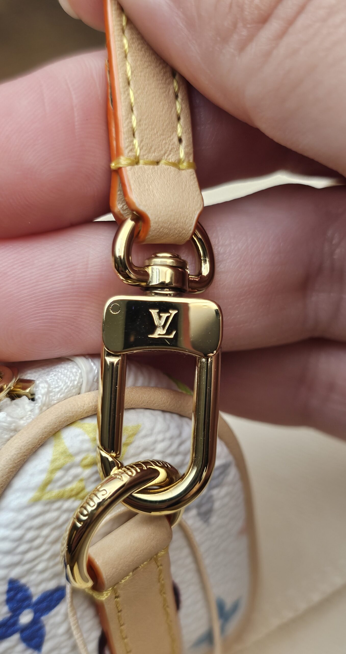 Close up of the gold-tone LV clasp on the strap