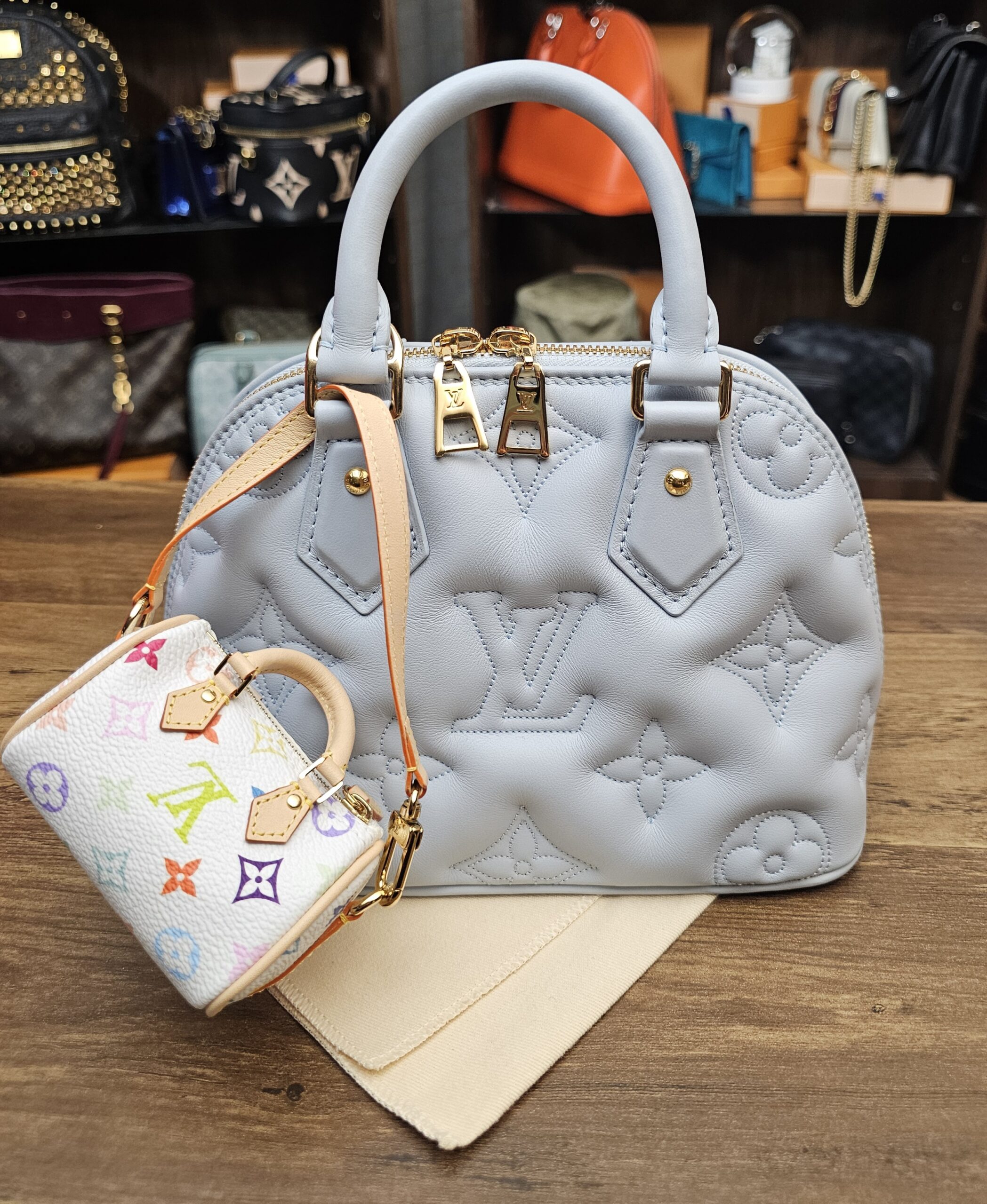 Micro Speedy hanging from a light blue quilted bag for scale