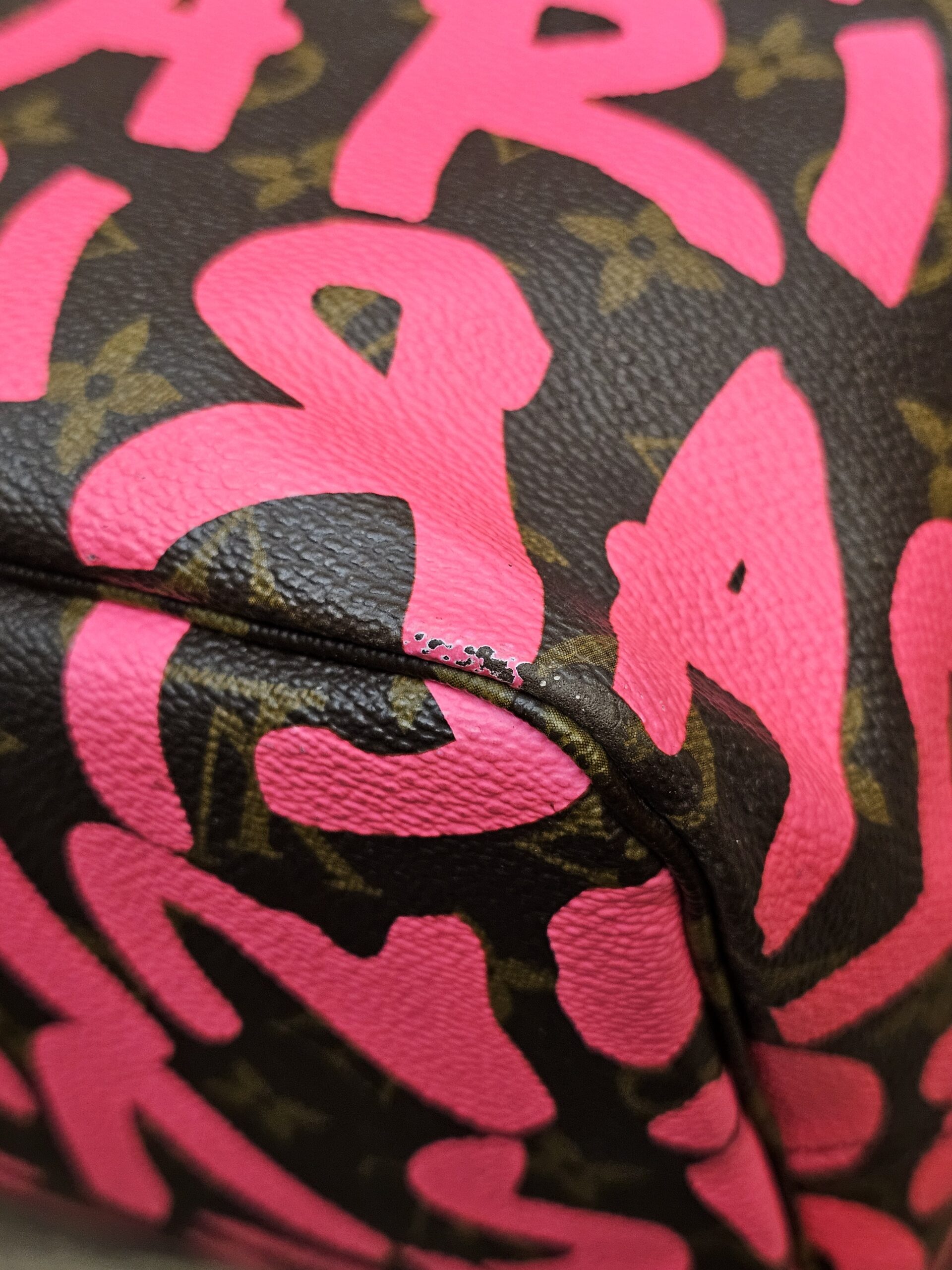 Close up of a base corner showing wear to the pink print
