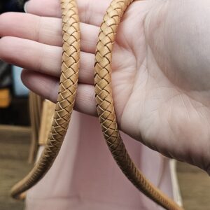 Braided vachetta handles held in hand