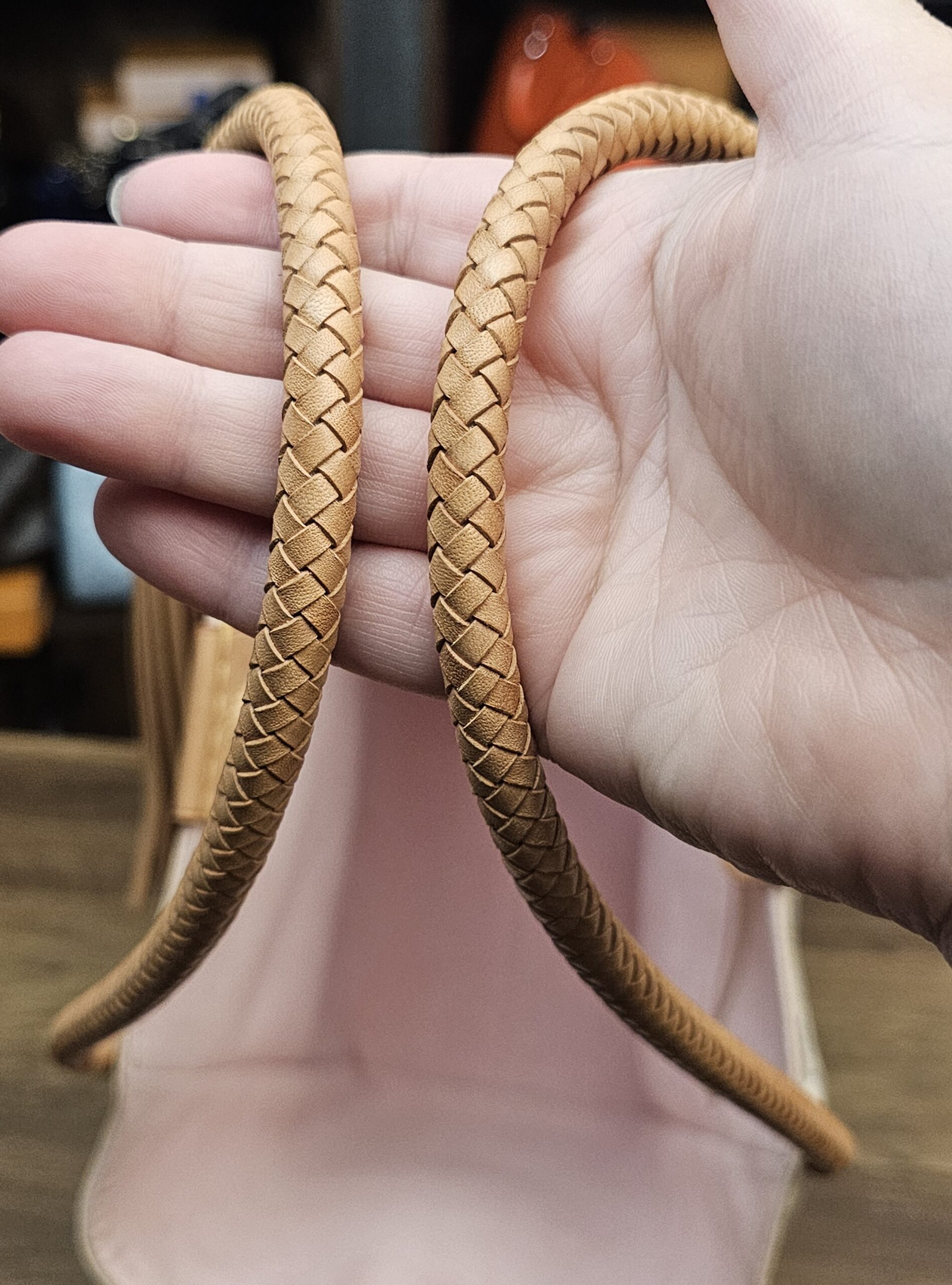 Braided vachetta handles held in hand