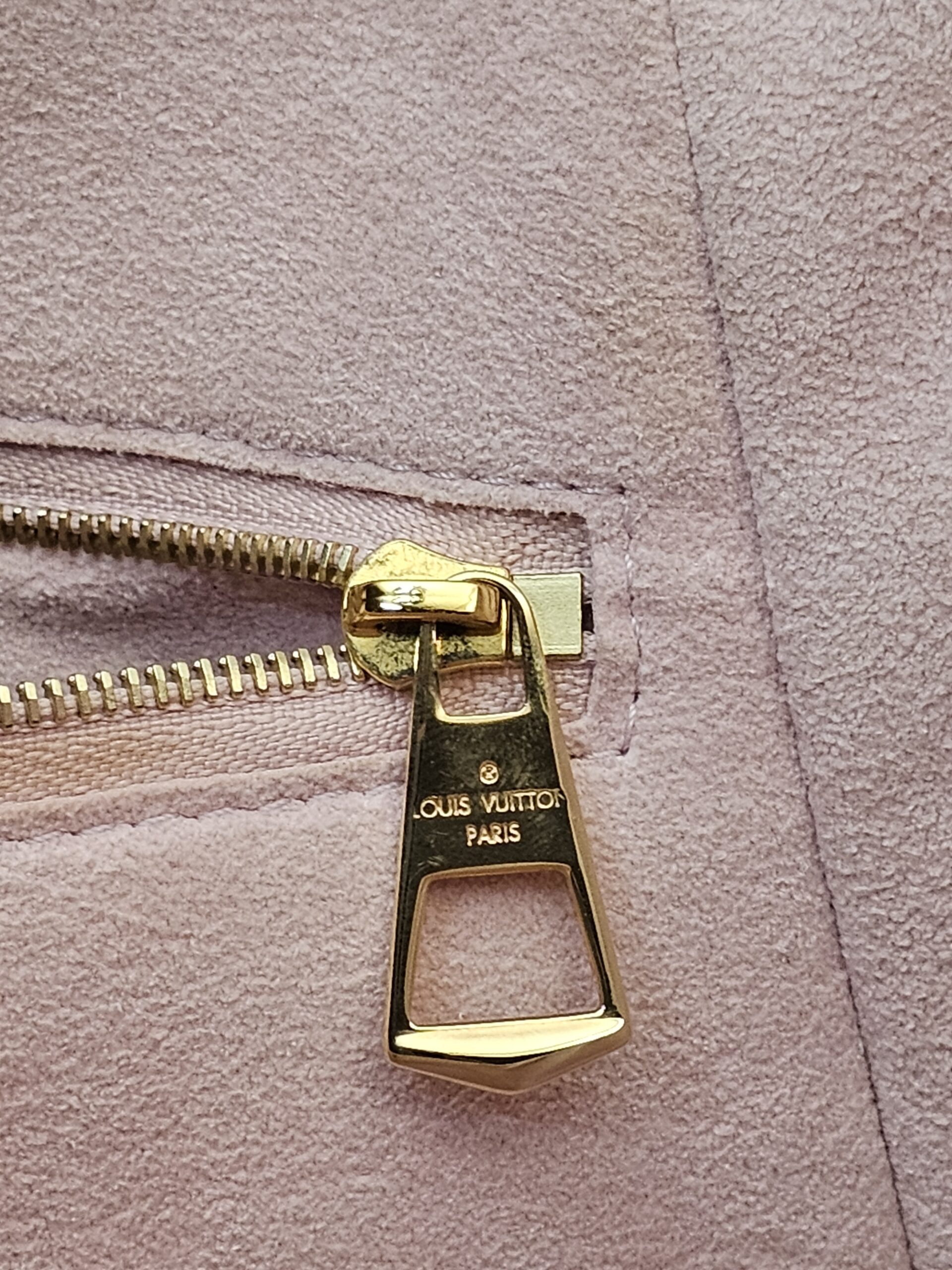 Gold-tone zip pull on the interior pocket