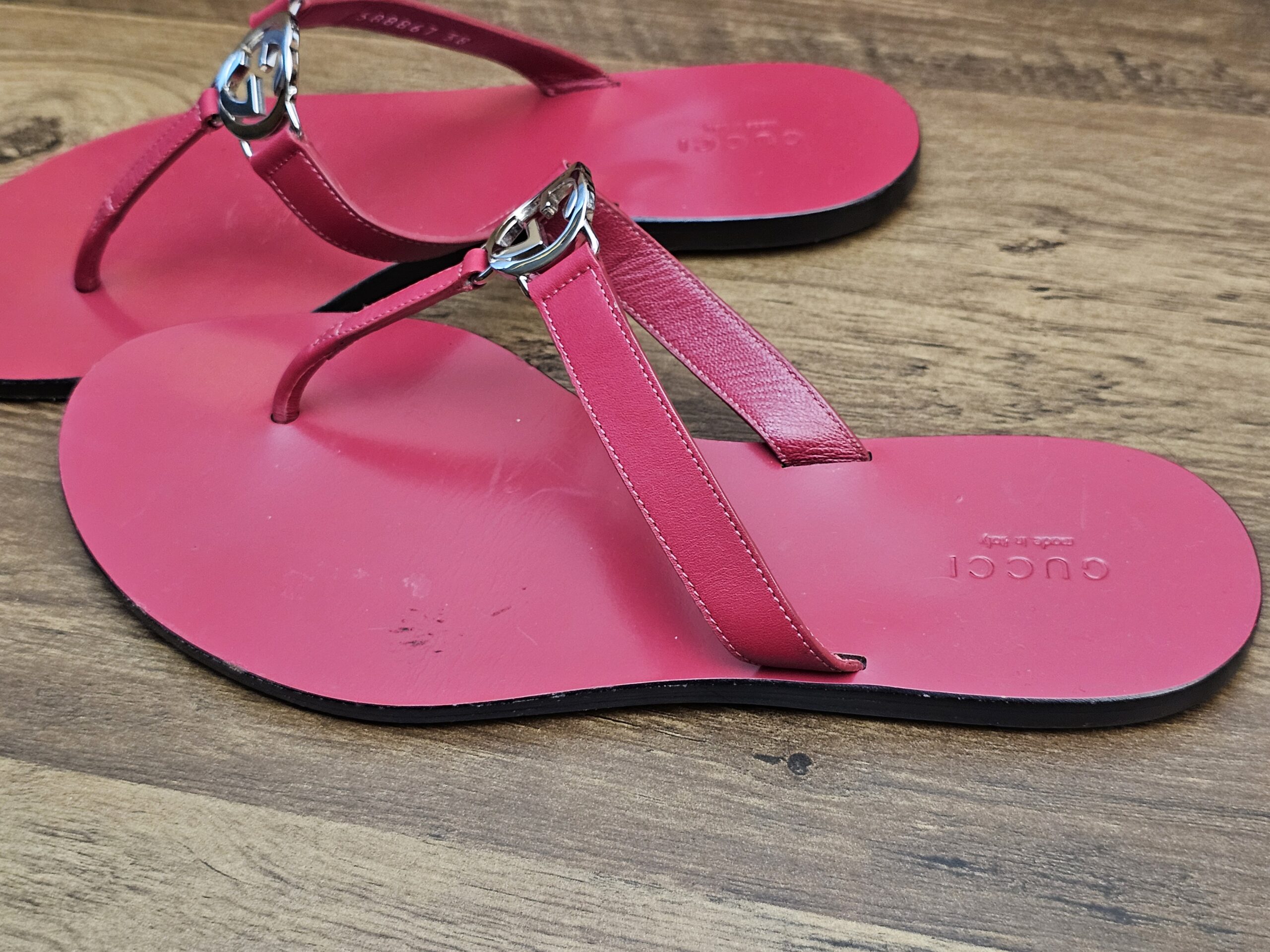 Pair from the side showing the toe posts and silver-tone logo buckles