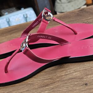 Pair at an angle showing the insole stamp and berry leather straps