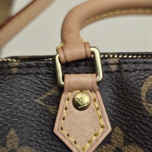 Close up of a vachetta tab and gold-tone handle ring