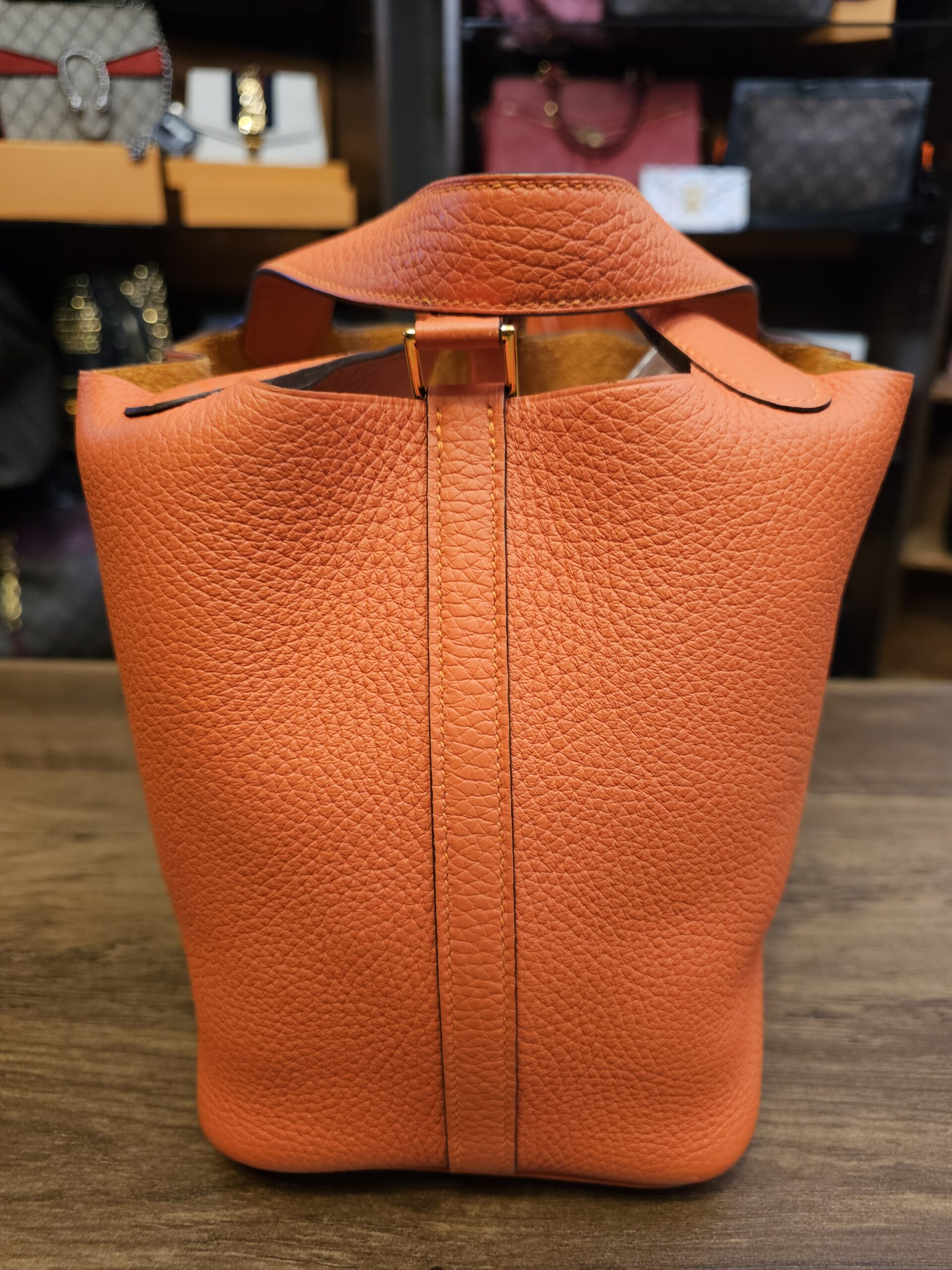 Side view showing the leather closure strap and gold-tone hardware