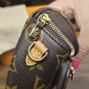 Bag held on its end showing the zipper and strap ring