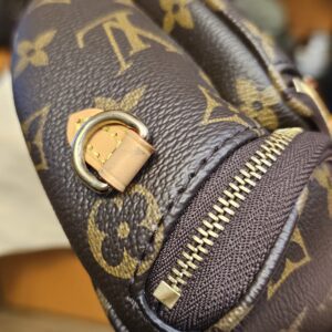 Close up of a leather strap tab and the zip edge