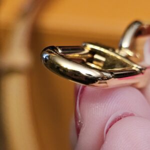 Close up of a gold-tone clasp showing light wear