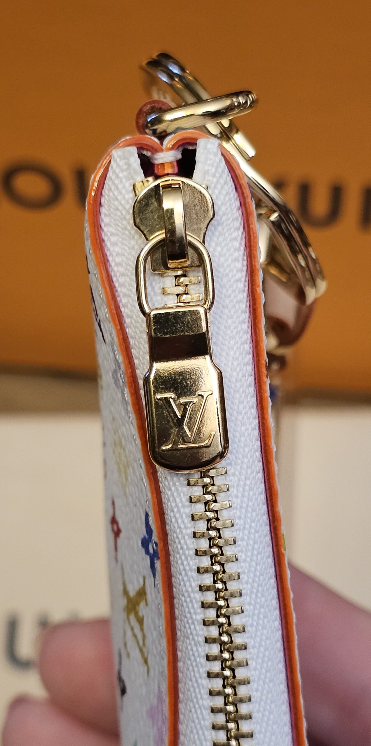 Side view of the gold-tone zip and LV pull