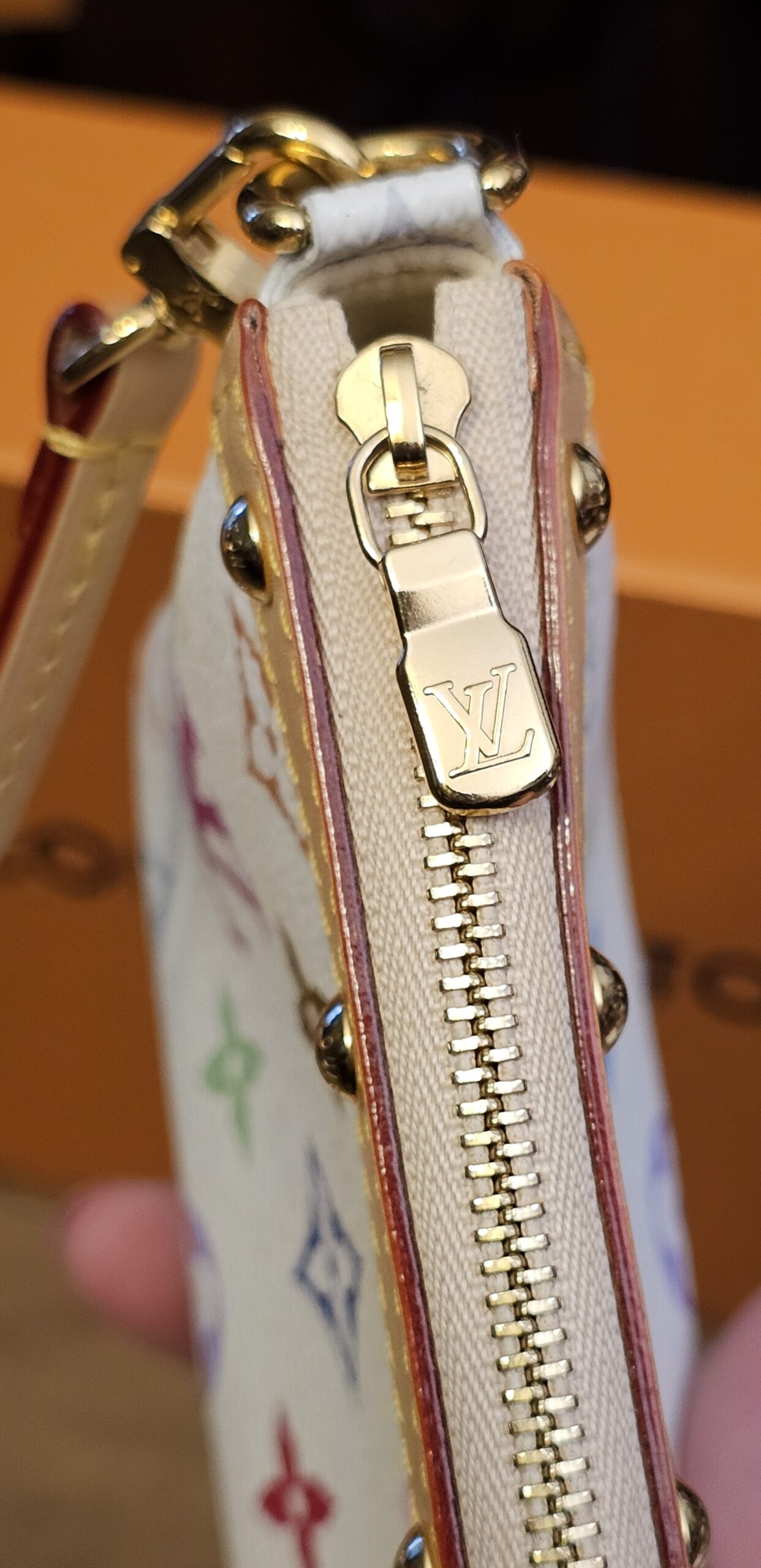 Gold-tone zip and LV zip pull along the top