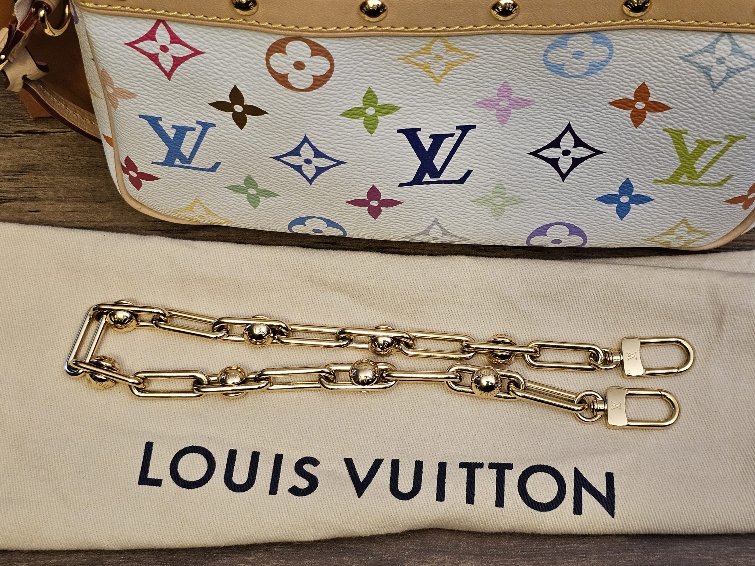 Removable gold-tone decorative chain on the dust bag