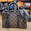 Louis Vuitton Monogram Soufflot BB Black - front view with the black leather strap and luggage tag