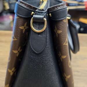 Side view showing the black grained leather side panel and strap ring