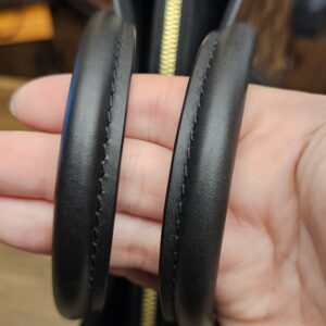 Rolled leather handles held together over the top zip