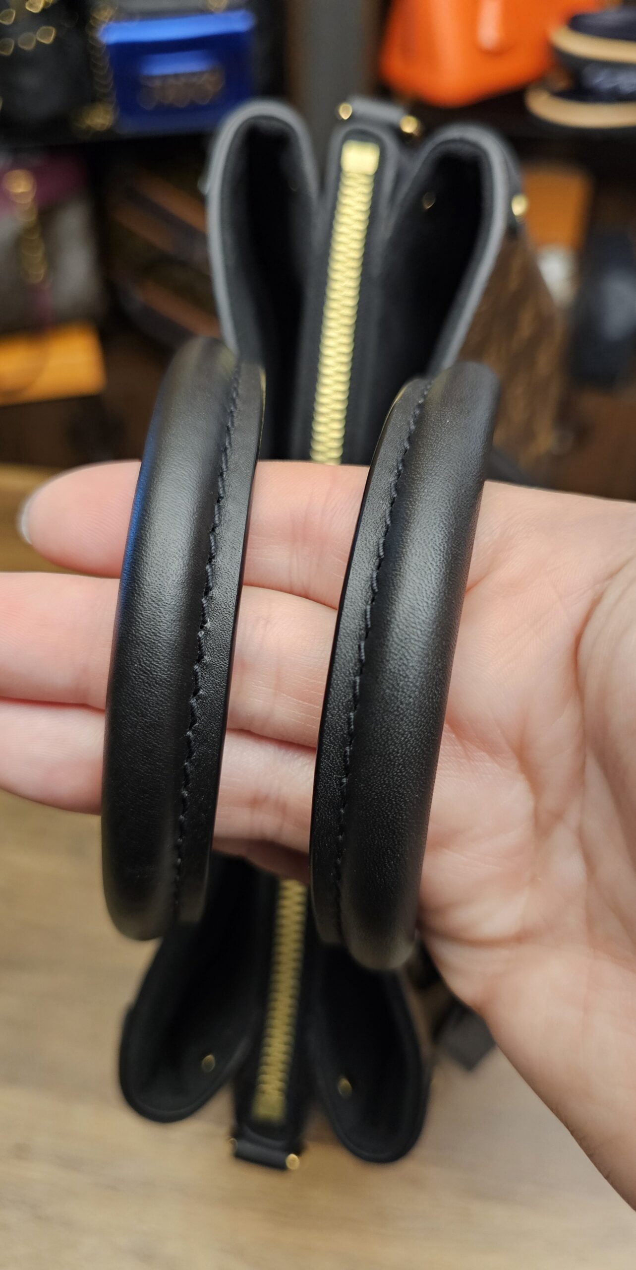 Rolled leather handles held together over the top zip