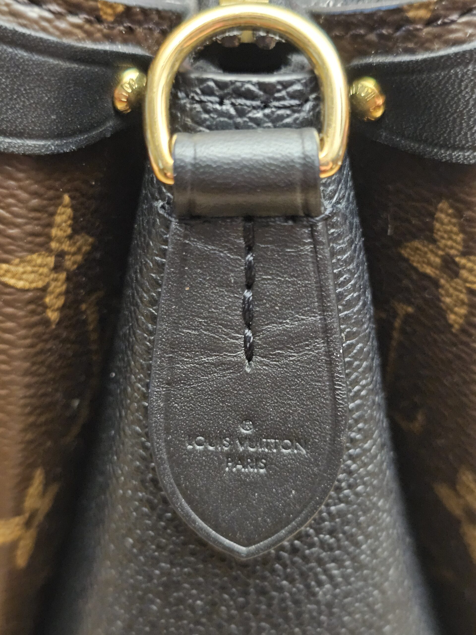 Leather side panel stamped LOUIS VUITTON PARIS below a gold-tone ring