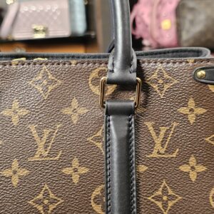 Handle base and leather tab against the Monogram canvas