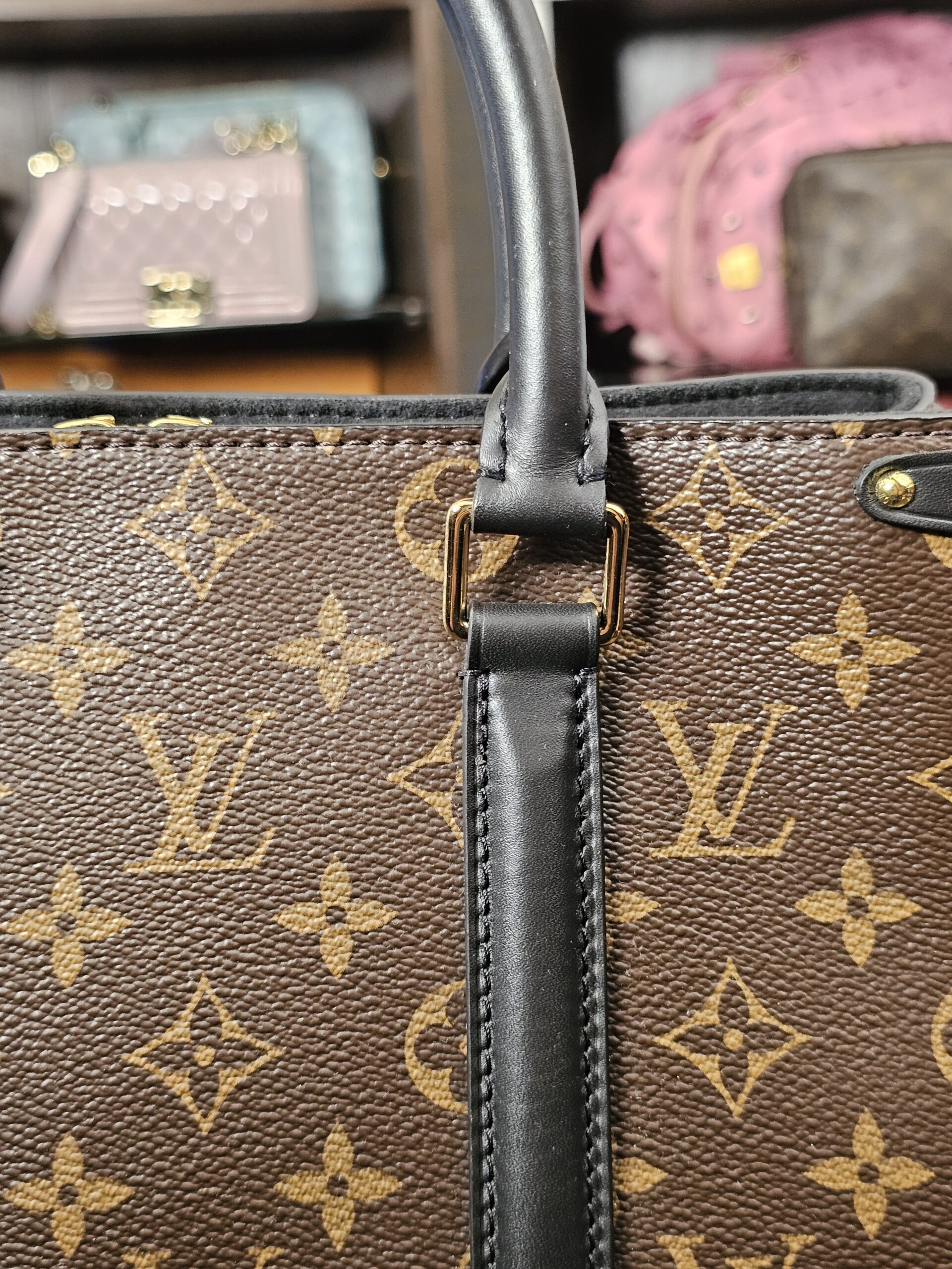 Handle base and leather tab against the Monogram canvas