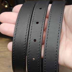 Removable black leather shoulder strap held in hand