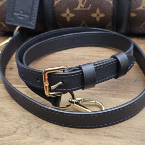 Shoulder strap laid out in front of the bag