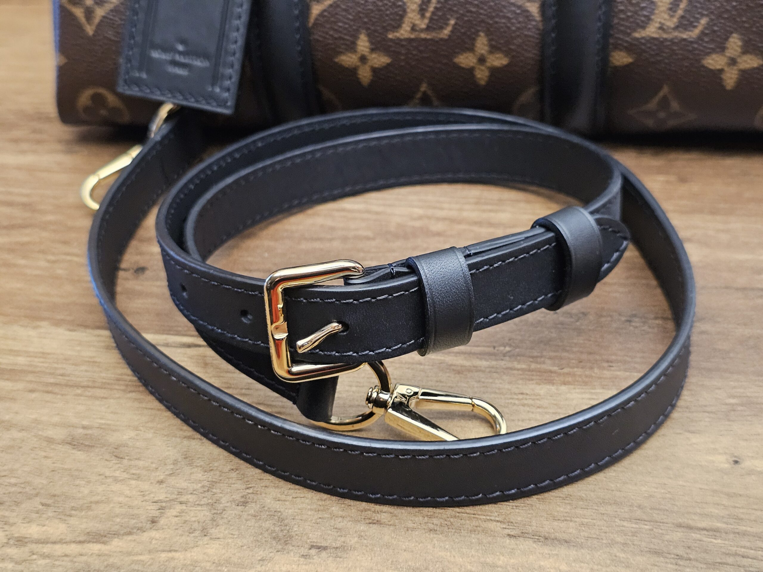 Shoulder strap laid out in front of the bag