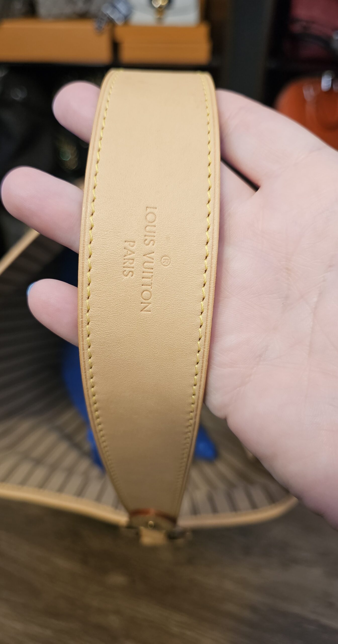 Underside of the wide vachetta shoulder strap with its stamp