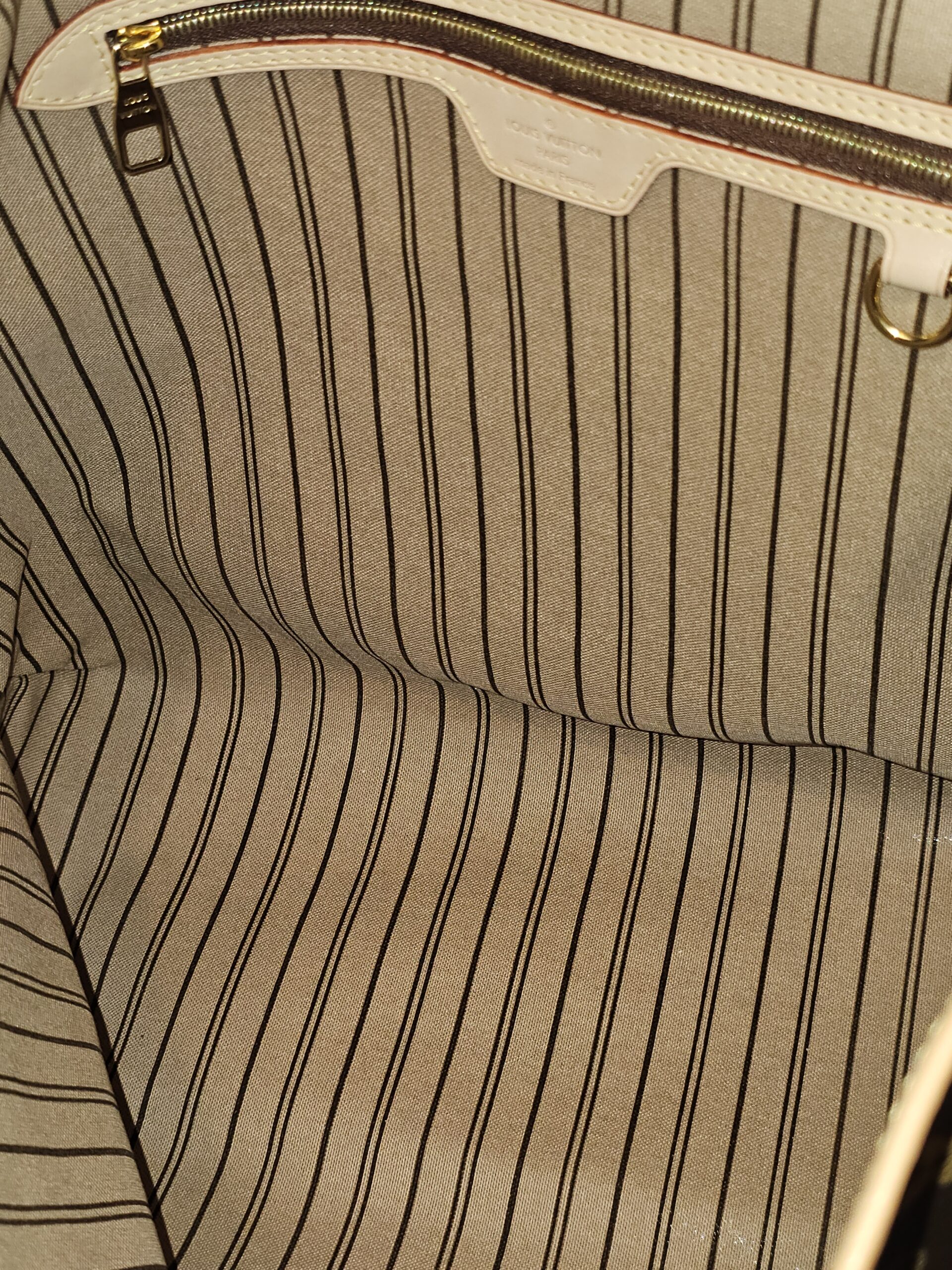 Interior zip pocket against the striped lining