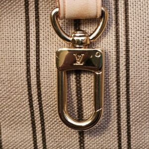 Gold-tone interior clasp on its vachetta strap