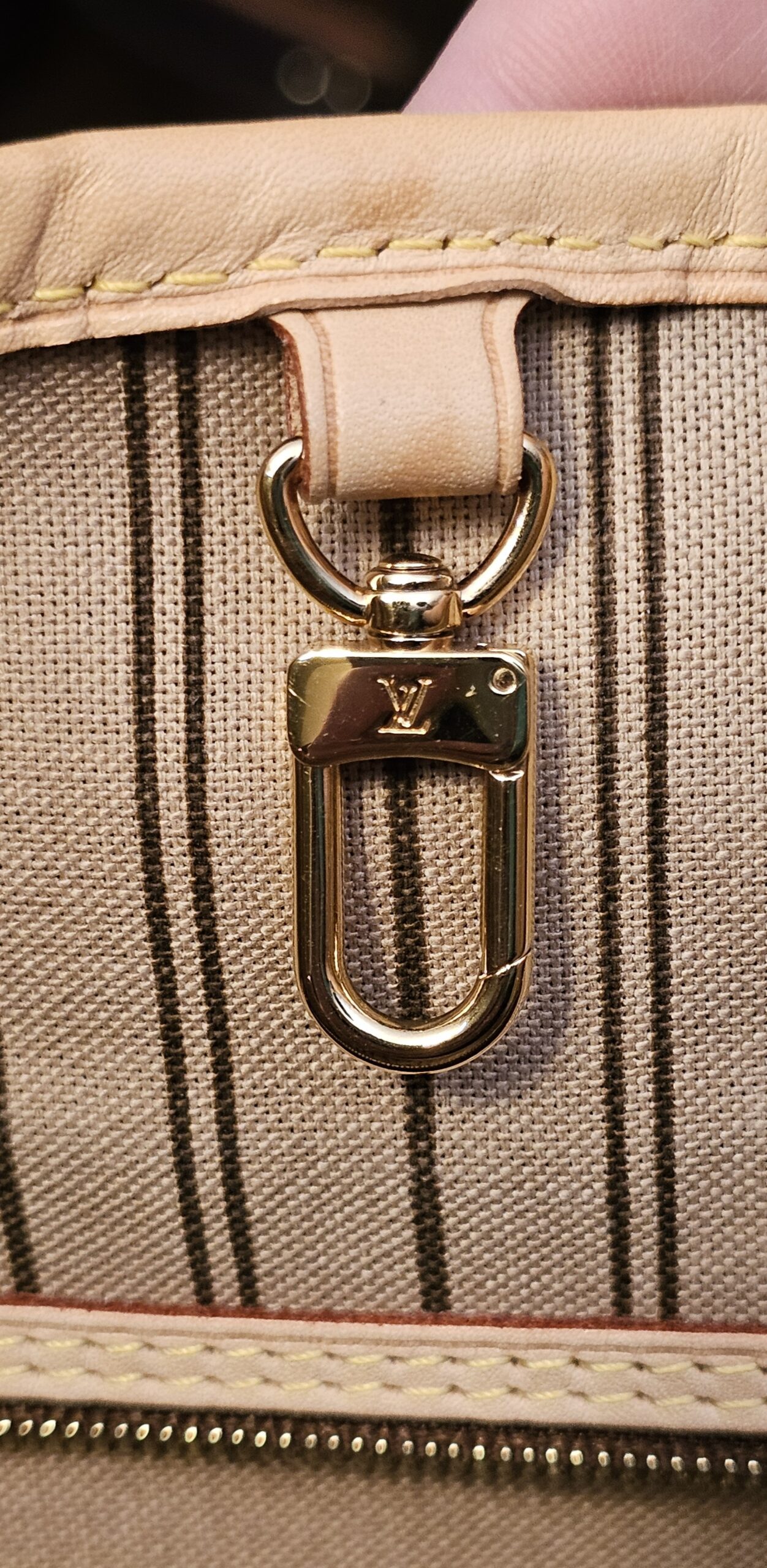 Gold-tone interior clasp on its vachetta strap