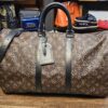 Louis Vuitton Monogram Macassar Keepall Bandouliere 45 - front view with black leather trim, luggage tag and shoulder strap