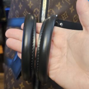 Black rolled leather handles held in hand