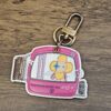 Louis Vuitton Vivienne 2019 Christmas Key Holder and Bag Charm Pink - front of the pink Vivienne travel artwork with key ring and clasp