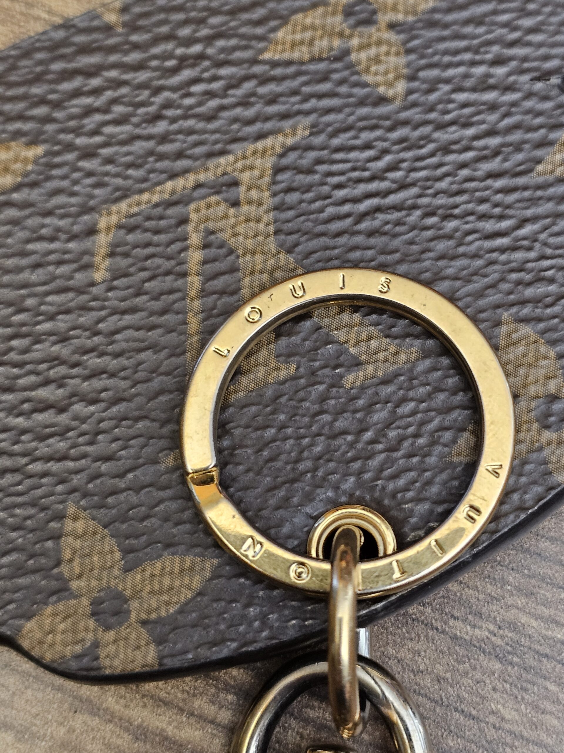 Engraved gold-tone key ring on the Monogram reverse