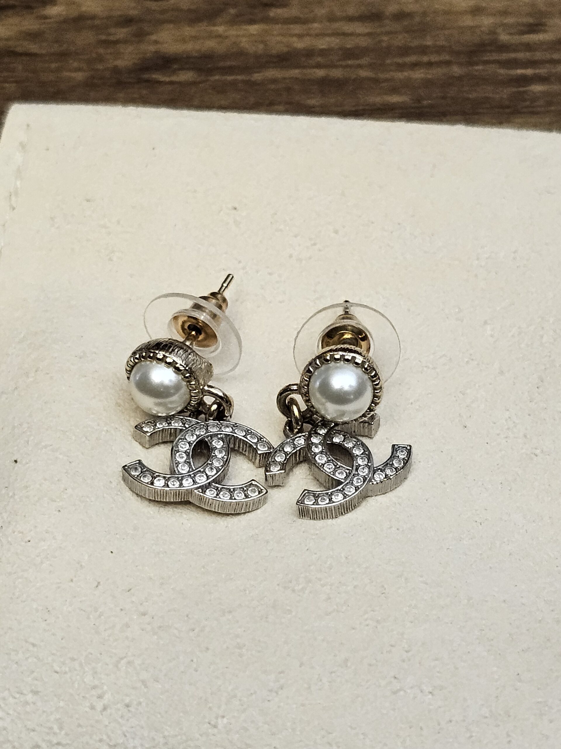 Pair laid flat showing the pearl studs and CC drops