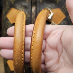 Rolled vachetta handles held up to show the patina