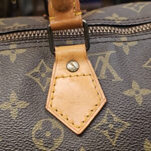 Handle tab close up showing light marks on the vachetta