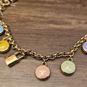 Enamel Monogram flower and LV charms along the gold-tone chain