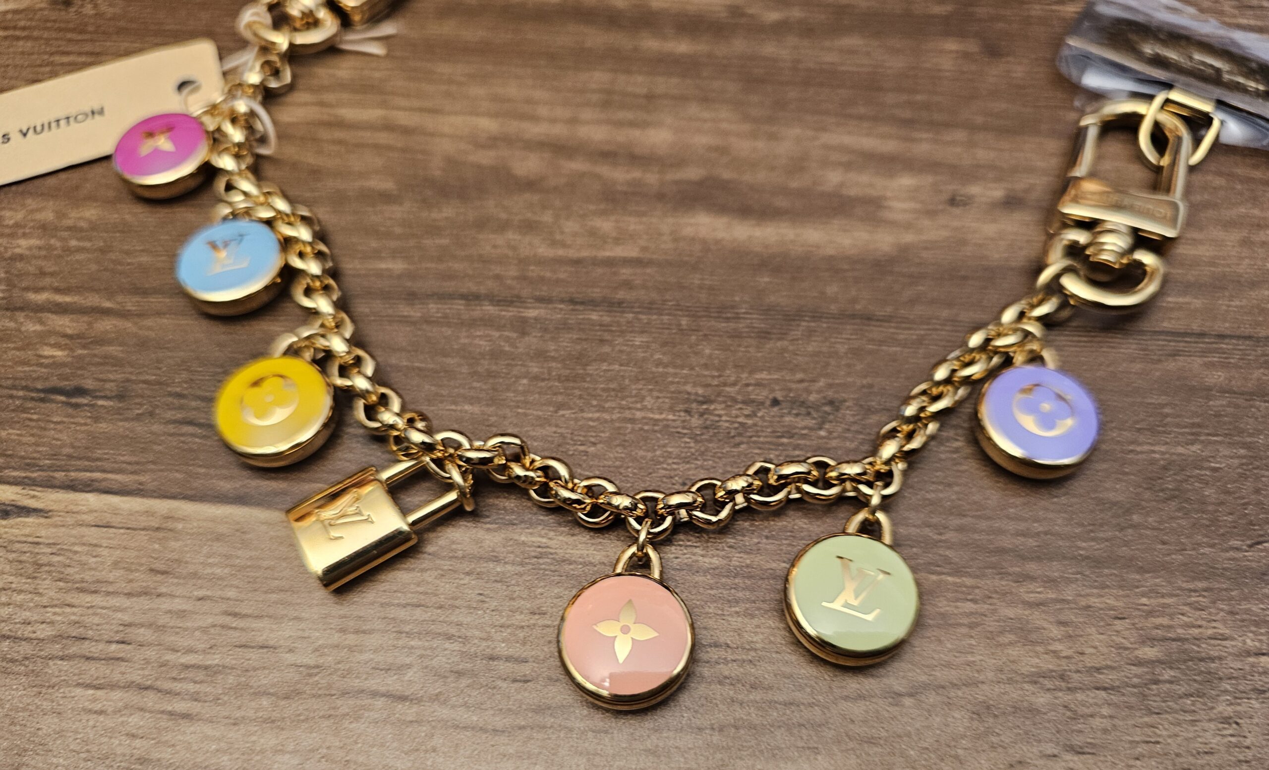 Enamel Monogram flower and LV charms along the gold-tone chain